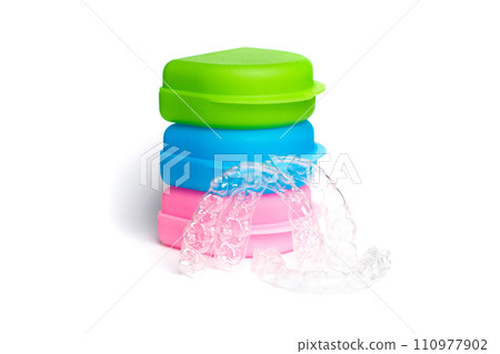 Colorful green, blue and pink box with invisible braces on white background 110977902