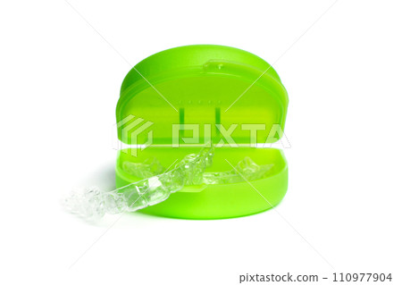Invisible dental aligners with green case on white background close up 110977904