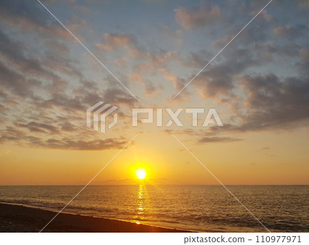 Orange and gold color sunset sky with clouds and ocean beach Orange and gold color sunset sky with clouds and ocean beach 110977971