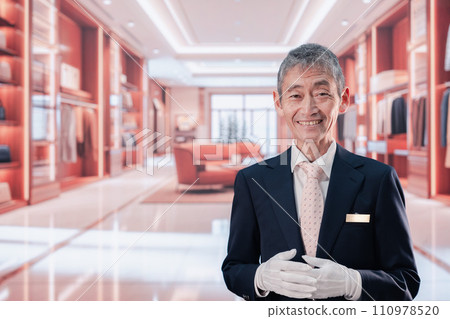一名中年男子在奢侈品牌店為顧客服務 一名中年男子在奢侈品牌店為顧客服務 110978520