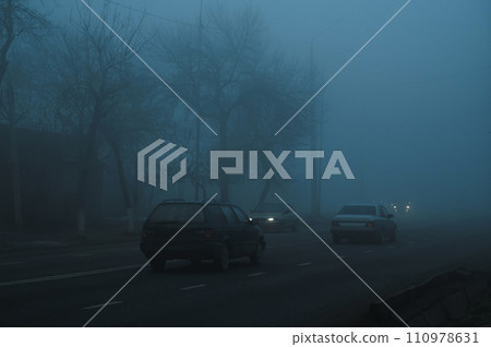 road with cars in city on a foggy morning in autumn in fog mist road with cars in city on a foggy morning in autumn in fog mist 110978631