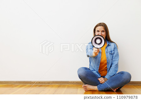 Woman with Megaphone Sitting on Wooden Floor Woman with Megaphone Sitting on Wooden Floor 110979878
