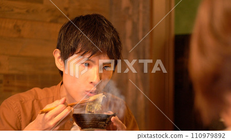 Young man eating dinner Young man eating dinner 110979892