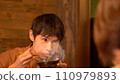 Young man eating dinner 110979893