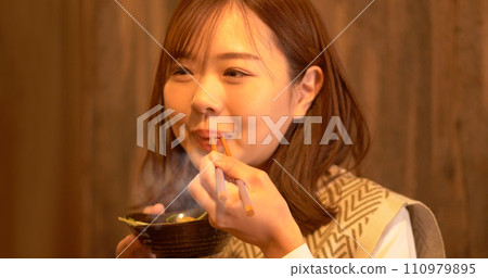 Young woman eating dinner 110979895