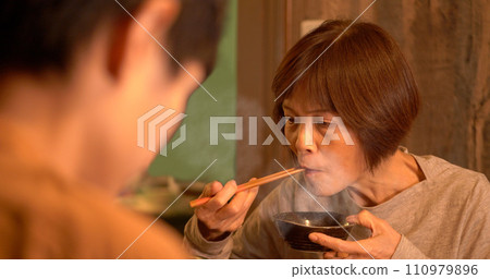 Senior woman having dinner with her parent and child 110979896