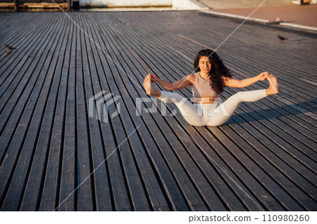 Woman doing yoga asana gymnastics breathing practice stretching 110980260