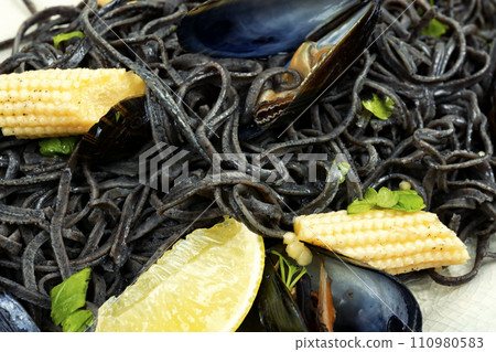 Black pasta with mussels and corn. 110980583