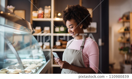 Generative AI The image depicts a happy African American woman using a smartphone in a bakery. 110980839