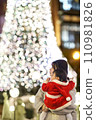 Girl looking at Christmas tree decorations 110981826