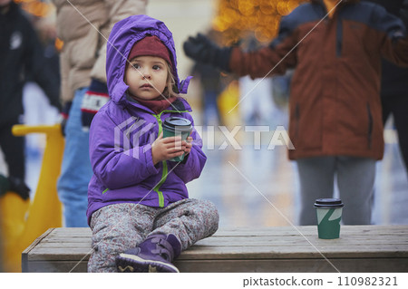 Charming child drinking coffee on the skating rink in Denmark 110982321
