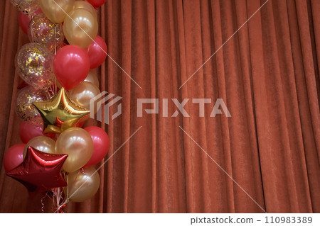 Orange closed curtain or drapery in theater with multicolored balloons with copy space. Theatrical performance concept. High quality photo Orange closed curtain or drapery in theater with multicolored balloons with copy space. Theatrical performance concept. High quality photo 110983389