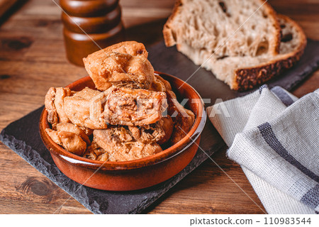Heap of domestic salty fried pork greaves. Fatty junk food. Pork greaves on the kitchen board. 110983544