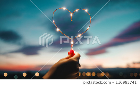 Holding A Heart Of Fairy Lights 110983741