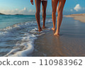 legs of a couple walking along the beach in the surf 110983962