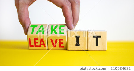 Take or leave it symbol. Businessman turns beautiful wooden cubes and changes words Leave it to Take it. Beautiful yellow table white background. Copy space. Business and take or leave it concept. 110984621
