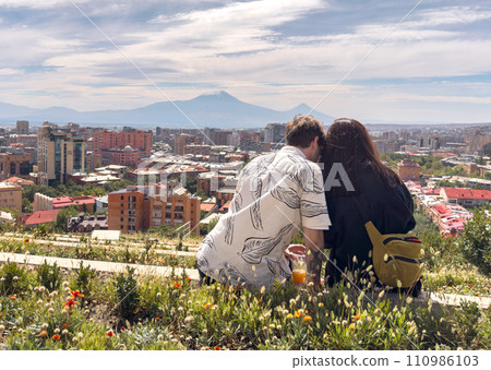 Love couple sitting high with panoramic view on Yerevan city and Ararat from Armenian cascade Love couple sitting high with panoramic view on Yerevan city and Ararat from Armenian cascade 110986103
