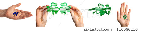 Hands holding shamrock glasses, green leaf shaped trinket. Irish accessories set for St Patricks day 110986116