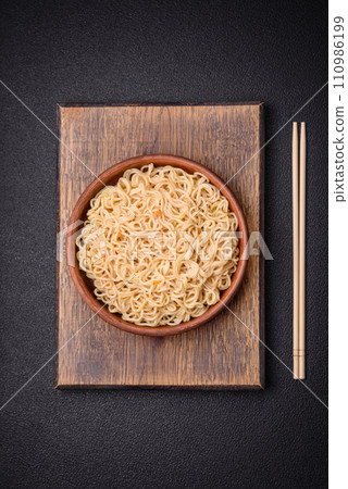 Delicious Asian cuisine dish with rice noodles, peppers, mushrooms and spices Delicious Asian cuisine dish with rice noodles, peppers, mushrooms and spices 110986199