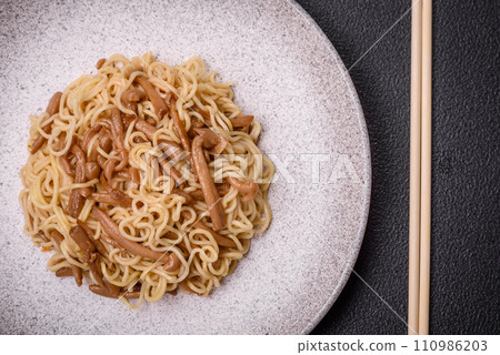 Delicious Asian cuisine dish with rice noodles, peppers, mushrooms and spices 110986203