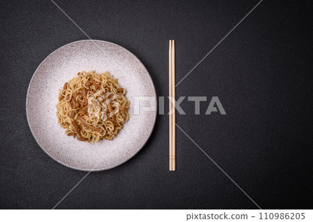 Delicious Asian cuisine dish with rice noodles, peppers, mushrooms and spices Delicious Asian cuisine dish with rice noodles, peppers, mushrooms and spices 110986205