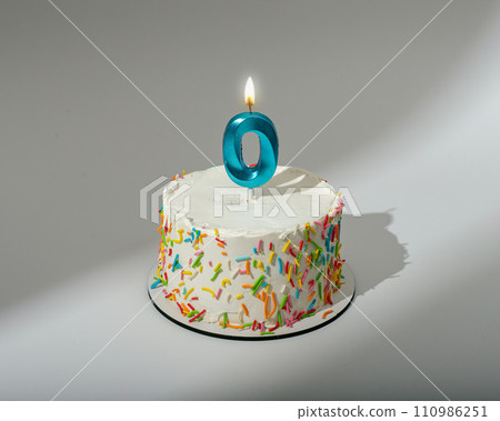 0 shaped candle light on happy birthday cake 110986251