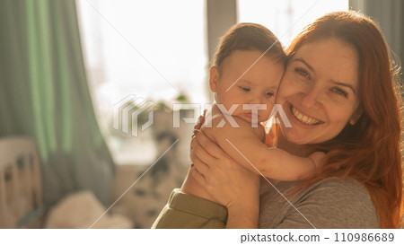 A Caucasian woman tenderly holds her newborn son in the morning rays of sunlight. A Caucasian woman tenderly holds her newborn son in the morning rays of sunlight. 110986689