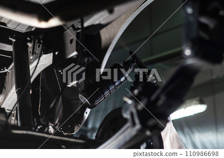 The master sprays an anti-corrosion compound on the bottom of the car.  110986698