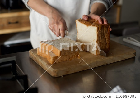 Cutting a loaf of bread bought with a bread knife 110987393