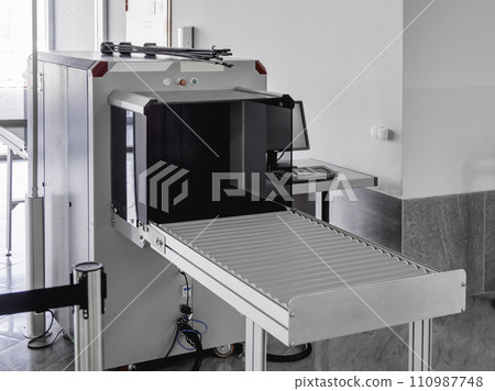 Metal detector frame and X-ray machine for checking luggage and hand baggage at entrance to public building. Checkpoint with security and anti-terrorist measures. Metal detector frame and X-ray machine for checking luggage and hand baggage at entrance to public building. Checkpoint with security and anti-terrorist measures. 110987748