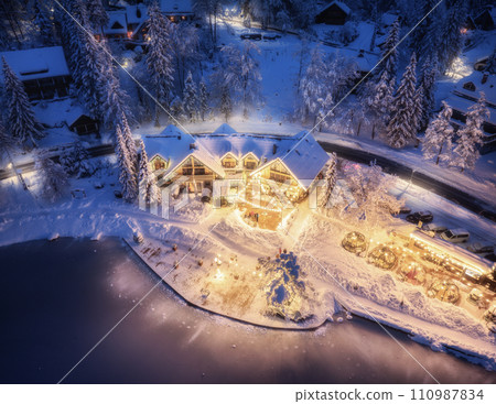 Aerial view of illuminated houses in snowy village at night 110987834