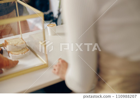 Close up of barista standing at the counter in coffee shop and waiting for order Close up of barista standing at the counter in coffee shop and waiting for order 110988207