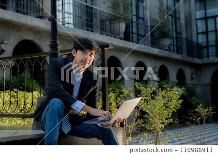 Successful businessman financier investors use laptops to communicate remotely over the internet or video call to set challenging business goals and ready to achieve targets from the outdoor hotel 110988911