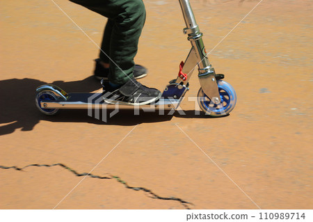Child riding a kickboard (5 year old/boy) 110989714
