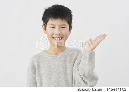 男孩用手掌指向右側，白色背景 110990180