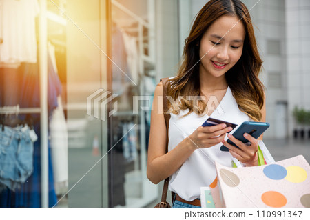 Consumer addiction in action ,young woman using her smartphone and credit card to make purchases while browsing an online store. Retail therapy at its most convenient Consumer addiction in action ,young woman using her smartphone and credit card to make purchases while browsing an online store. Retail therapy at its most convenient 110991347