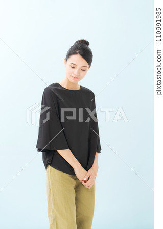 一名 30 多歲的女性，身穿黑色襯衫，低頭看去 110991985