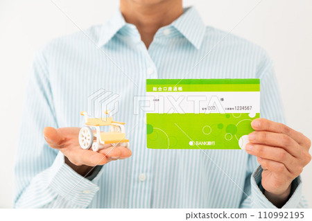 Middle-aged woman with a wheelchair model and a bankbook Middle-aged woman with a wheelchair model and a bankbook 110992195