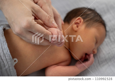 A newborn boy holds his mother's finger. Close-up of hands. A newborn boy holds his mother's finger. Close-up of hands. 110992328