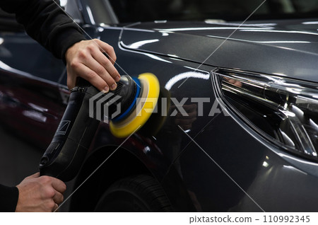 A master polishes the surface of a car body. A master polishes the surface of a car body. 110992345
