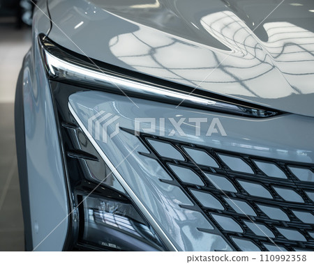 Close-up of the headlight of a white modern car.  110992358