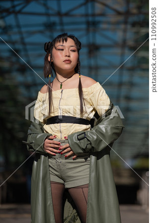 A beautiful Asian woman in shorts and a green leather coat comes out of the subway. A beautiful Asian woman in shorts and a green leather coat comes out of the subway. 110992508