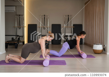 Two pregnant women do a plank with bolsters. Yoga for pregnant women. Two pregnant women do a plank with bolsters. Yoga for pregnant women. 110993074
