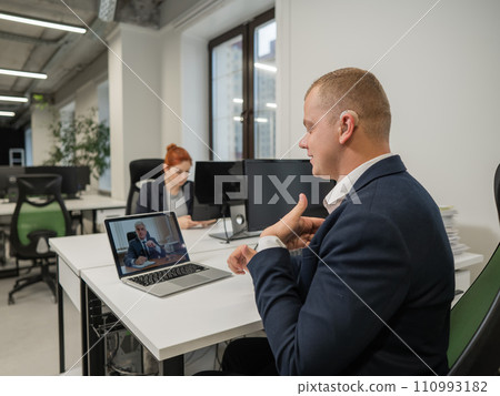 Business partners are talking in sign language to a video call. Two men at a remote business meeting. Business partners are talking in sign language to a video call. Two men at a remote business meeting. 110993182