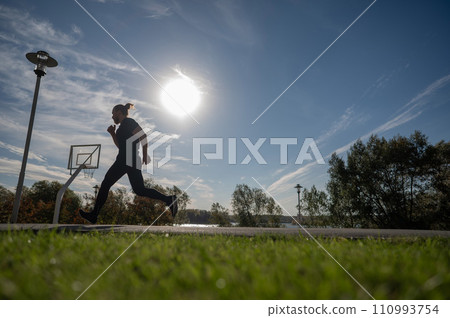 Caucasian man jumping with high hip raise outdoors.  110993754