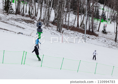 A skiers slides down the mountain over white snow in a altai ski resort. Seasonal sports. A skiers slides down the mountain over white snow in a altai ski resort. Seasonal sports. 110994783