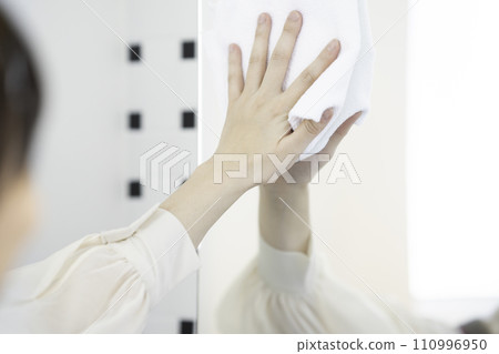 A woman in an apron wiping the sink A woman in an apron wiping the sink 110996950