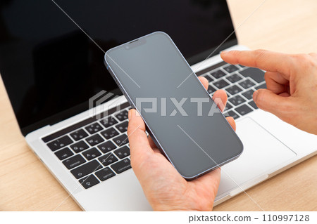 Hand of a middle-aged woman holding a smartphone Hand of a middle-aged woman holding a smartphone 110997128