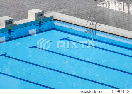 Top view swimming pool outlined by bold lanes, inviting swimmers to glide through clear turquoise water. lanes, neatly divided by marker lines, perfect for training and competition 110997490