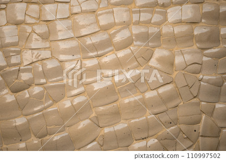 Cracked ceramic tile mosaic in beige and gray background, catching glimmers of light. Evokes a sense of vintage charm and rustic beauty Cracked ceramic tile mosaic in beige and gray background, catching glimmers of light. Evokes a sense of vintage charm and rustic beauty 110997502